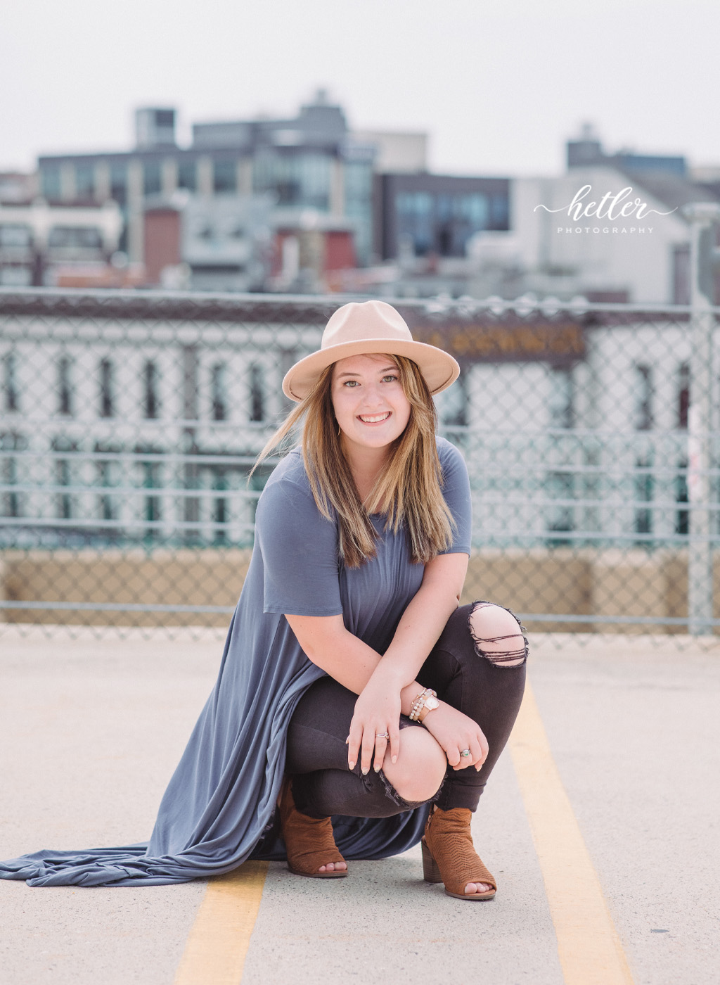 downtown Grand Rapids senior photos with a high school senior girl in a felt hat, ripped black jeans and trendy outfit