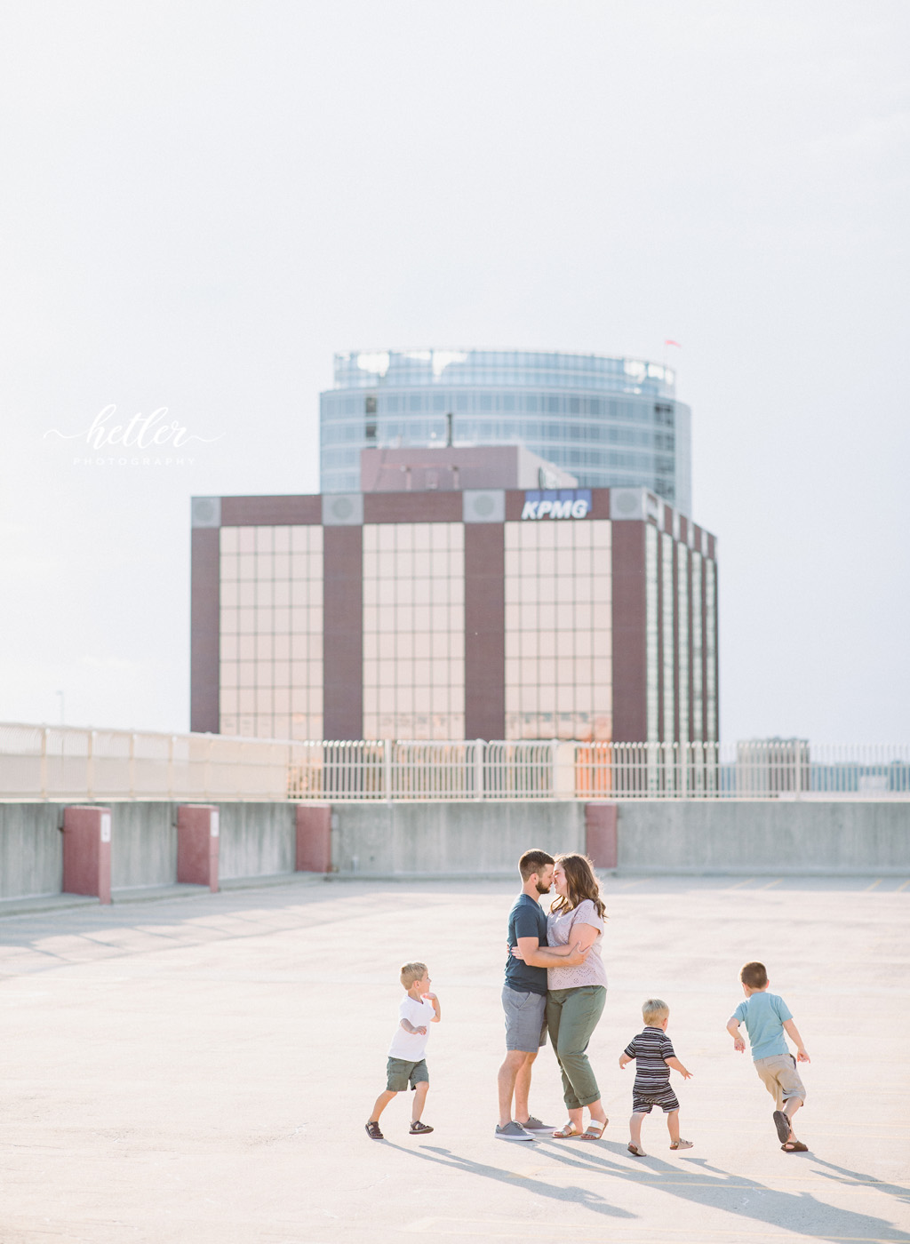 Downtown Grand Rapids family pics on a parking garage rooftop with views of the city and with a white breeze block wall