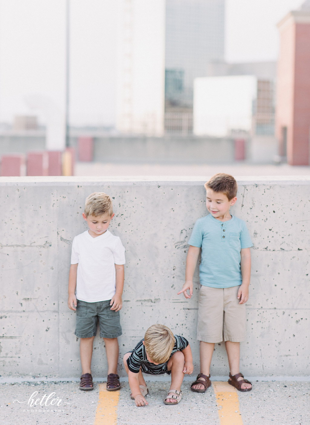 Downtown Grand Rapids family pics on a parking garage rooftop with views of the city and with a white breeze block wall