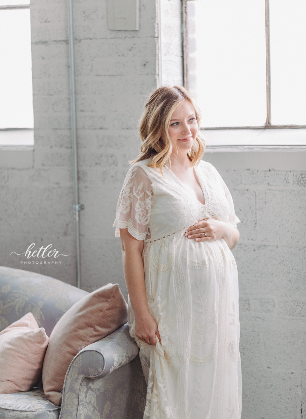 Grand Rapids maternity photos at a natural light studio with mom in a beautiful white dress