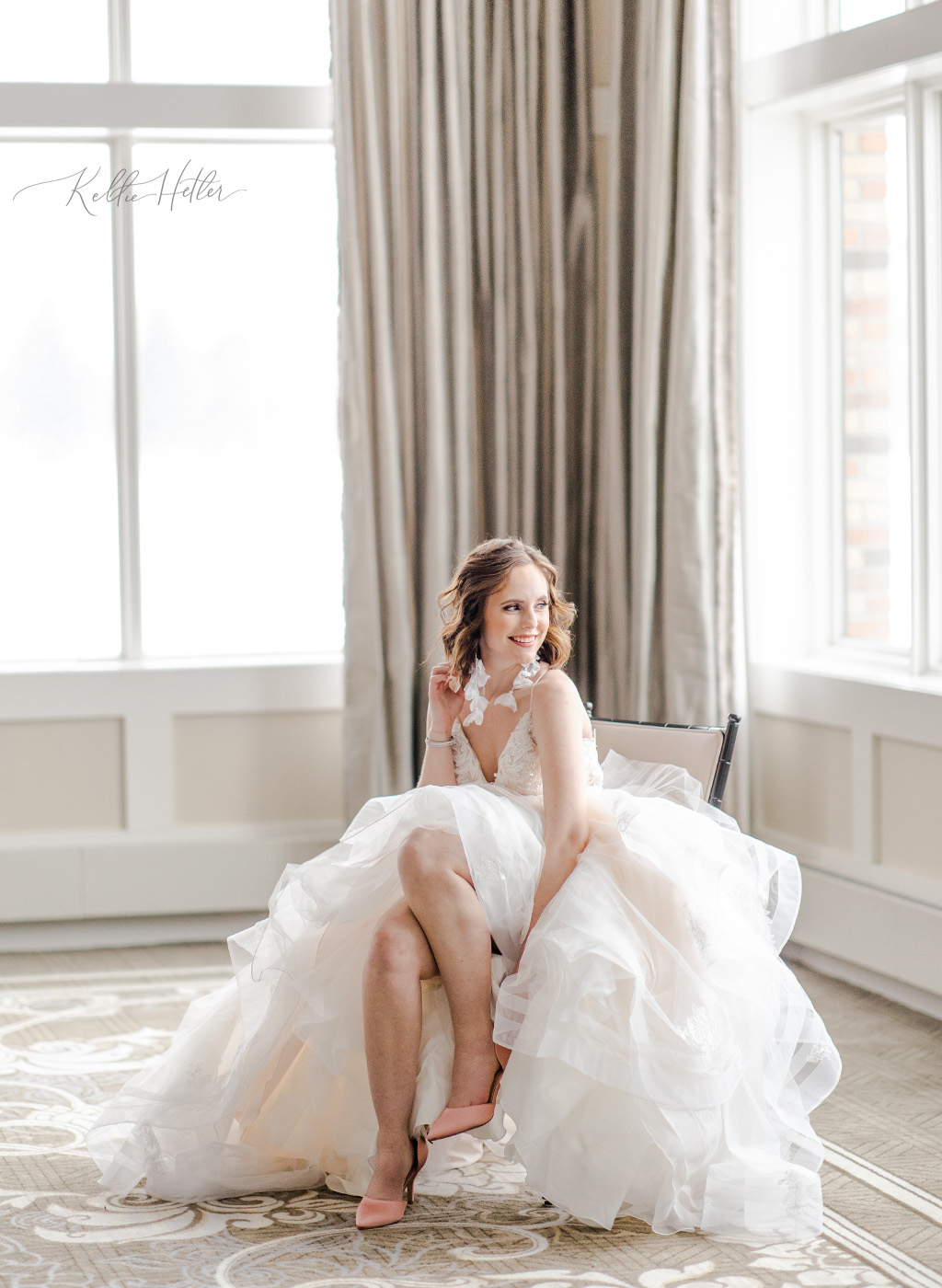 bride putting on shoes wearing big fluffy tulle dress