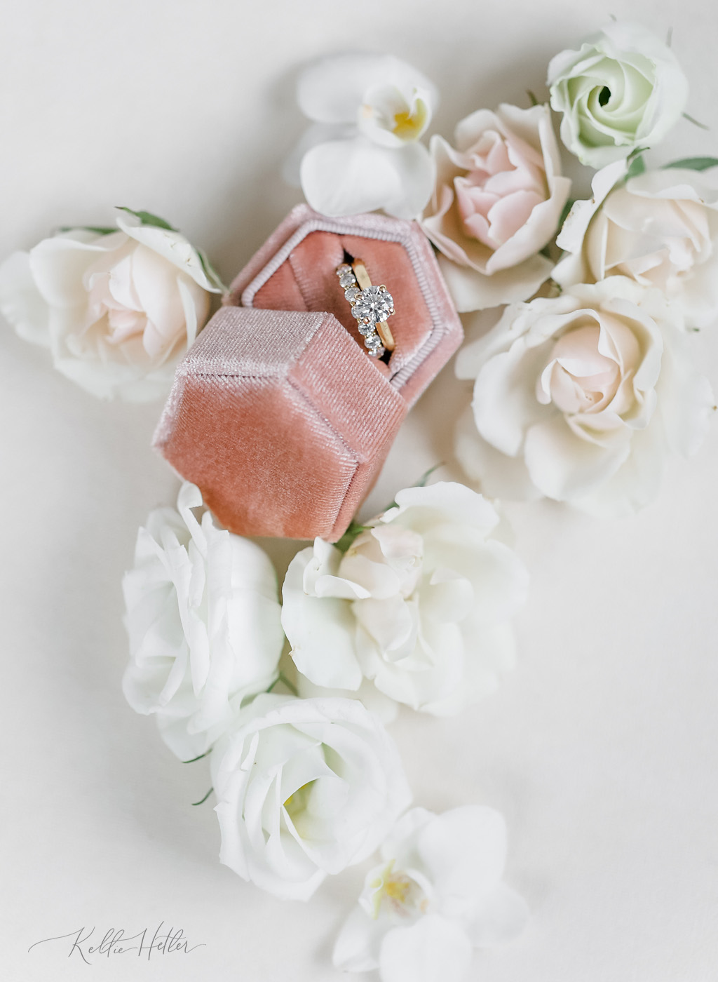 Wedding rings sitting in velvet ring box surrounded by flowers