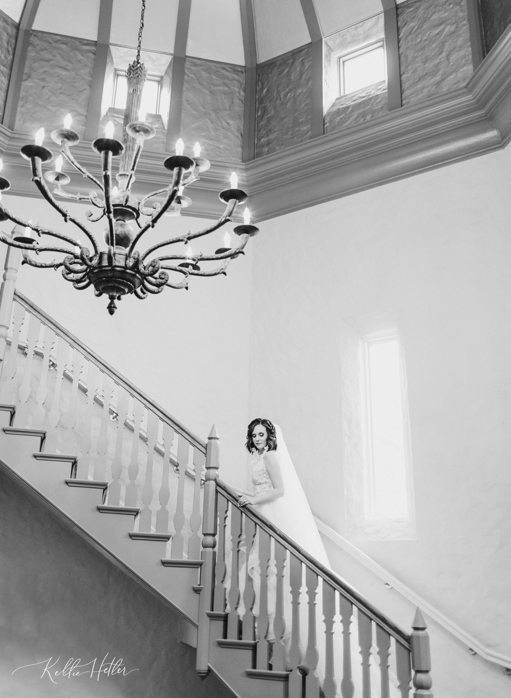 Bride walking grand staircase at Cascade Hills Country Club in Grand Rapids