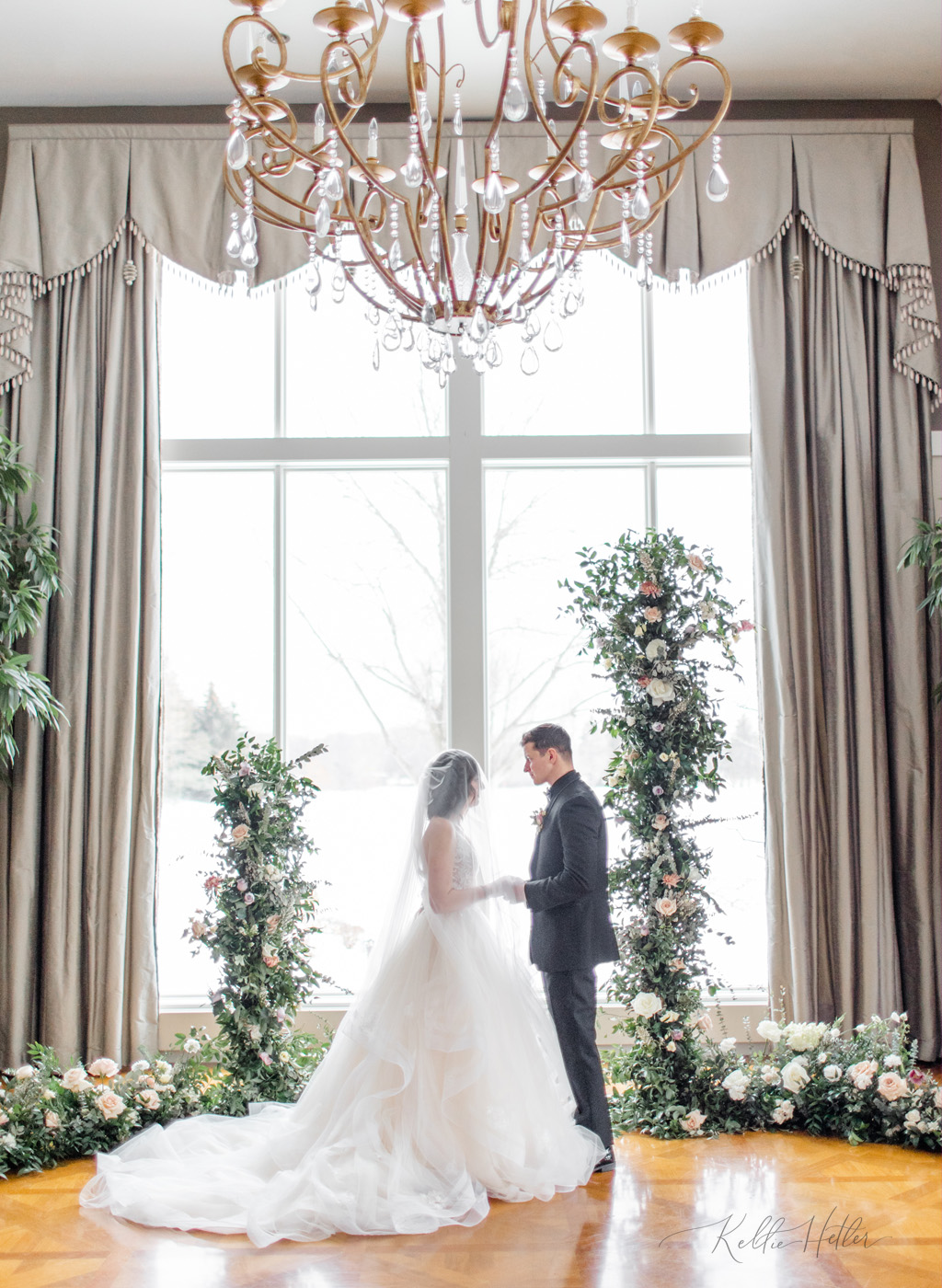 Indoor wedding ceremony in front of snowy backdrop at Cascade Hills Country Club