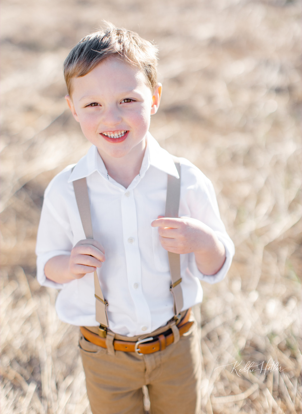 Little boy in neutral field with suspenders
